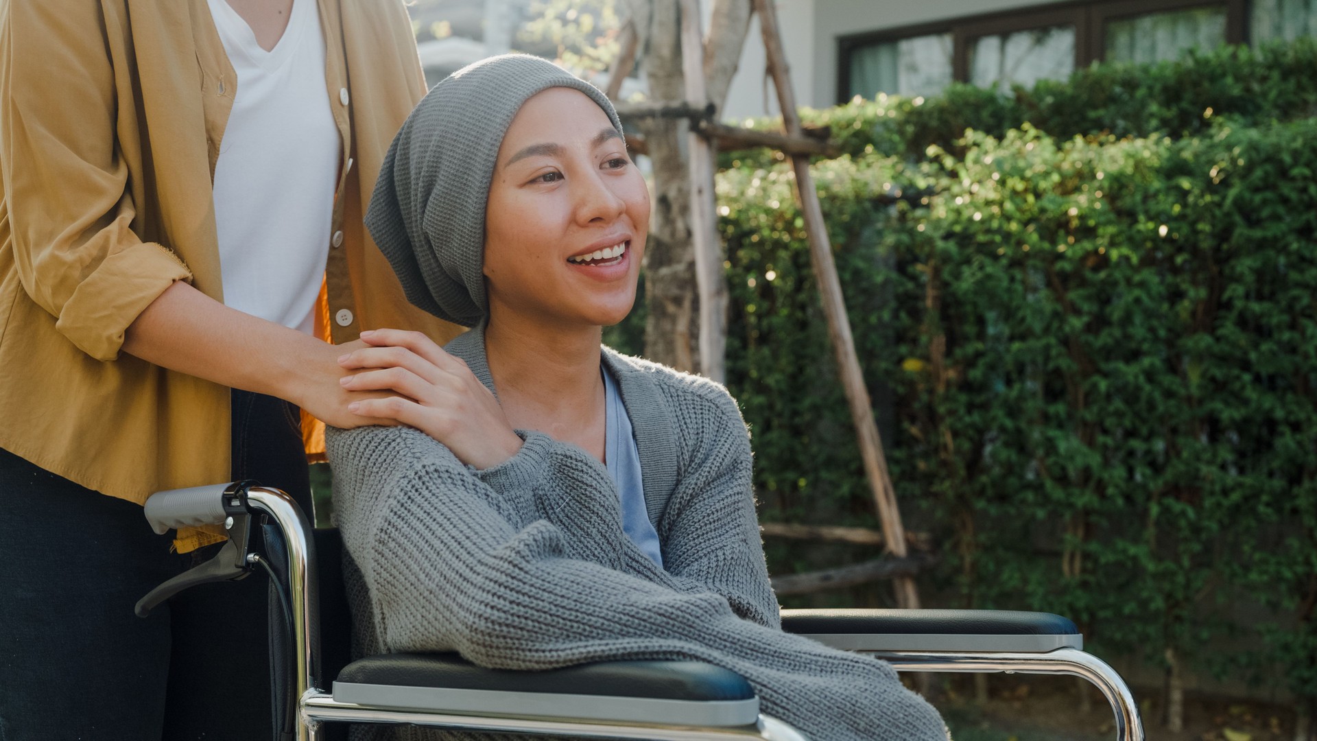 Young Asian people holding hands trust comfort help cancer patients talk crying stress relief outside home. Healthcare.