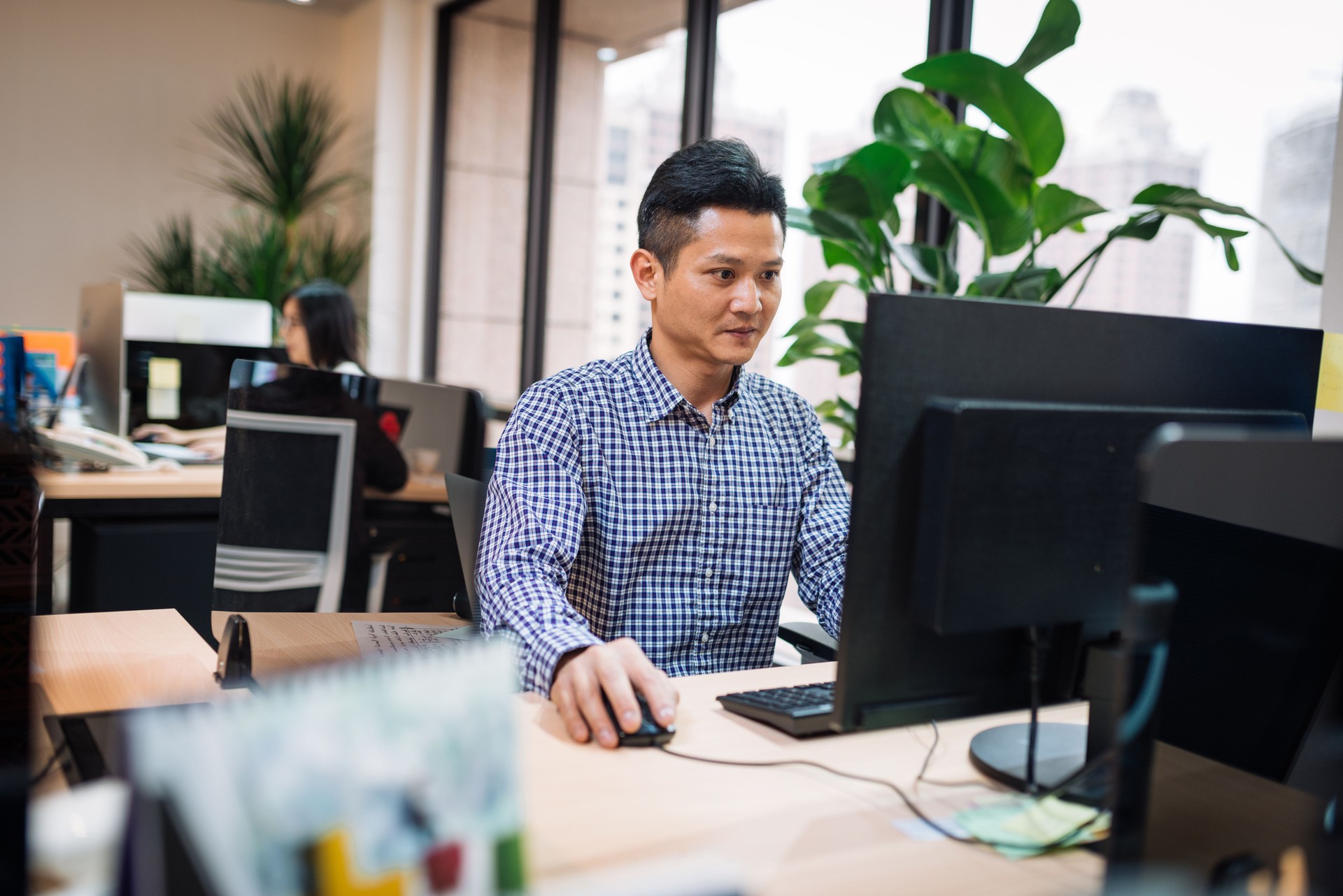 Administrative worker in Asia, working on computer.